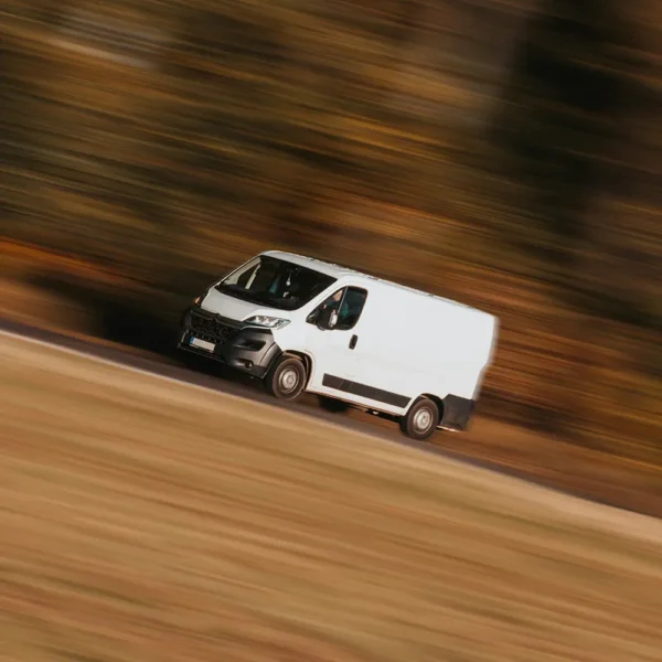 a white van driving on a road